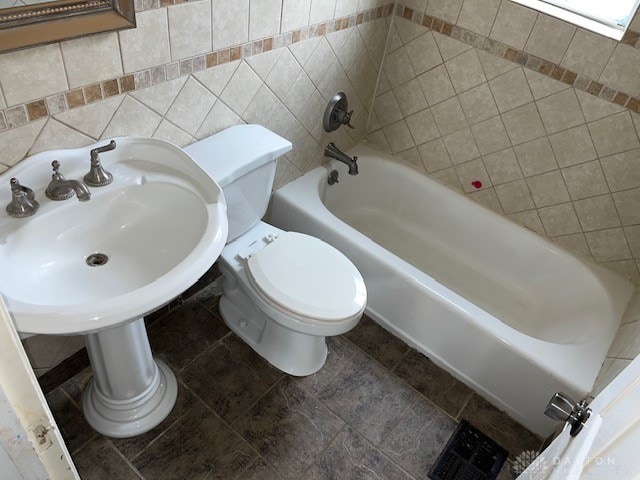 bathroom featuring toilet, tile walls, and tub / shower combination