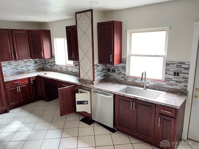 kitchen featuring light tile patterned floors, tasteful backsplash, sink, and stainless steel dishwasher