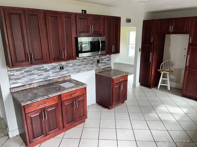 kitchen featuring decorative backsplash and light tile patterned floors