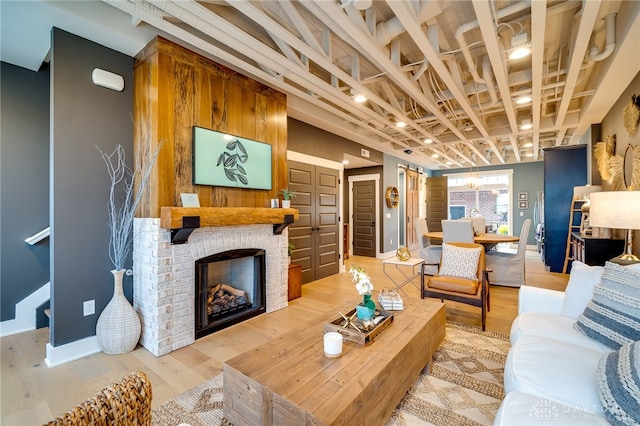 living room with an inviting chandelier, a fireplace, and hardwood / wood-style floors