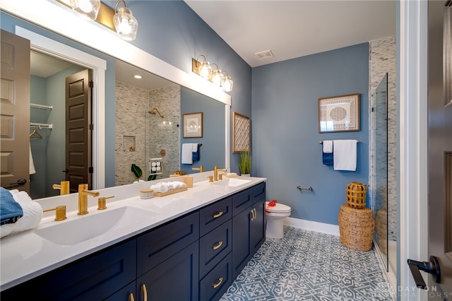 bathroom featuring vanity, a shower with shower door, toilet, and tile patterned flooring