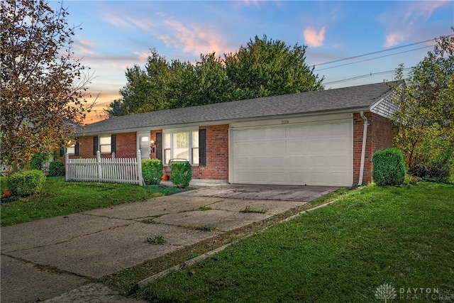 single story home with a lawn and a garage