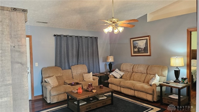 living room with a textured ceiling, vaulted ceiling, dark hardwood / wood-style floors, and ceiling fan