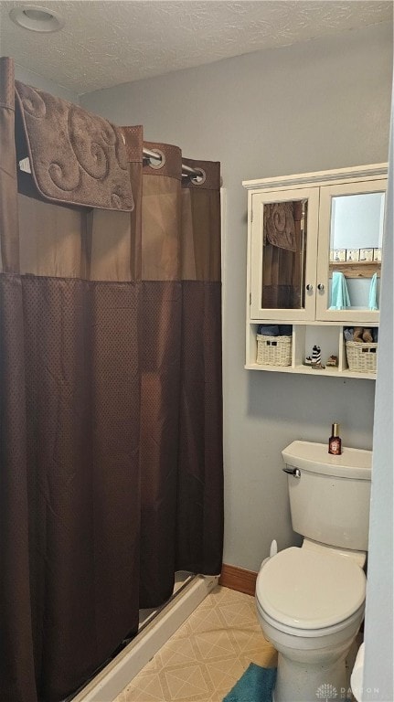 bathroom featuring toilet, a textured ceiling, and a shower with shower curtain