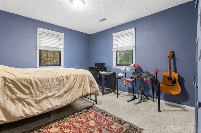 bedroom featuring visible vents, a textured ceiling, and baseboards