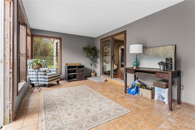 living area featuring baseboards and tile patterned flooring