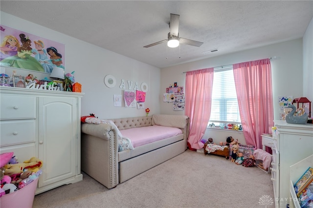 bedroom with a textured ceiling, ceiling fan, and light carpet