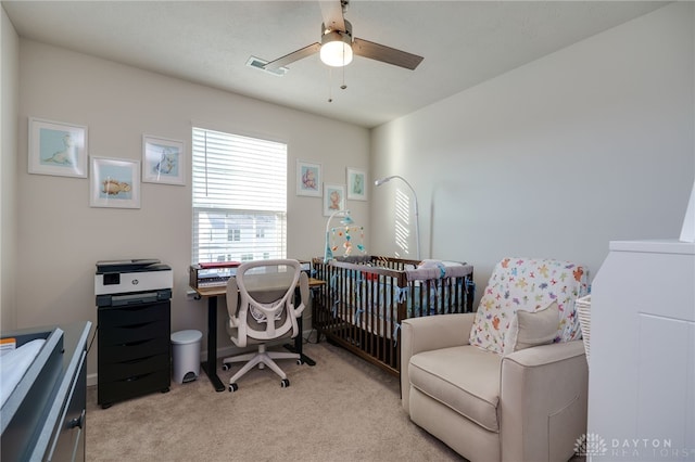 office space featuring a ceiling fan, visible vents, and light carpet