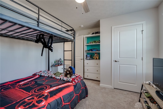 bedroom featuring light carpet, a textured ceiling, and ceiling fan