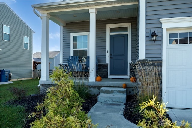 entrance to property featuring covered porch and a garage