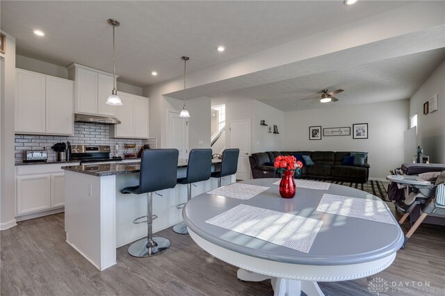 dining area with ceiling fan and light wood-type flooring