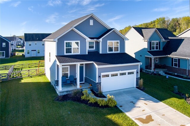 view of front of property with covered porch, a garage, and a front lawn