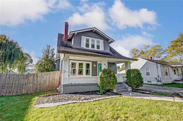 view of front of property with covered porch and a front lawn