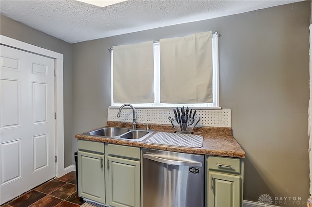 kitchen with stainless steel dishwasher, green cabinets, sink, and a textured ceiling