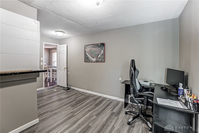 office space featuring wood-type flooring and a textured ceiling