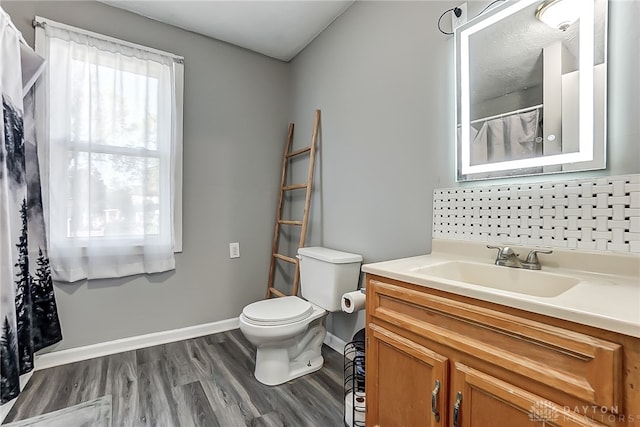 bathroom featuring decorative backsplash, hardwood / wood-style floors, a healthy amount of sunlight, and toilet