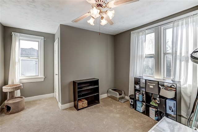 miscellaneous room featuring a textured ceiling, ceiling fan, and light carpet