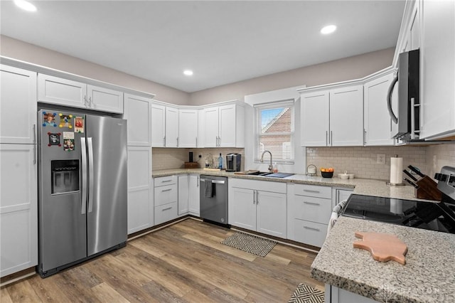 kitchen featuring white cabinets, sink, hardwood / wood-style floors, and appliances with stainless steel finishes