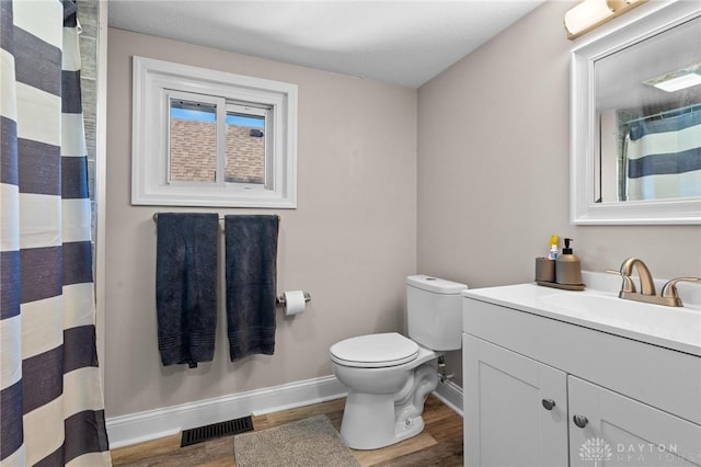 bathroom featuring toilet, vanity, and hardwood / wood-style flooring