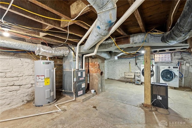 basement featuring heating unit, washing machine and dryer, and water heater