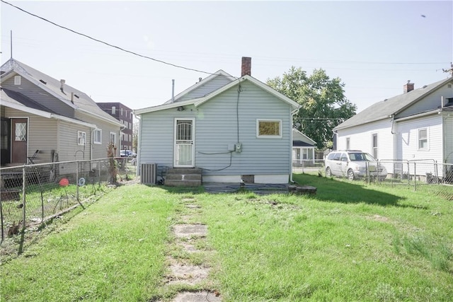 rear view of property featuring a lawn