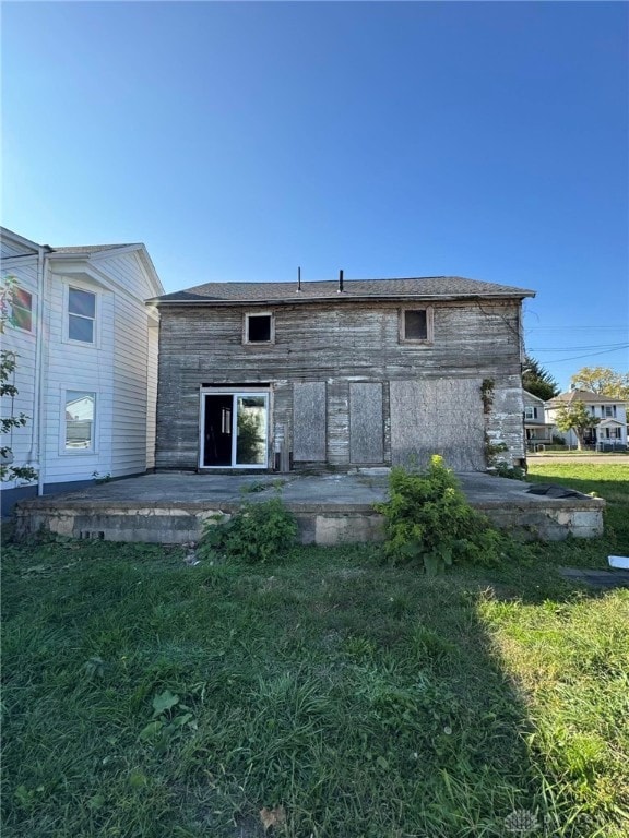 back of property featuring a patio and a lawn