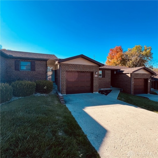 single story home featuring a garage and a front yard