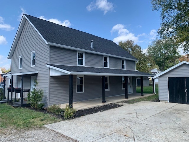 view of front of home featuring a porch and a storage unit