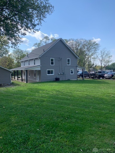 rear view of property with a lawn