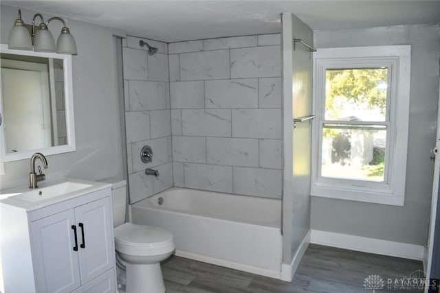 full bathroom with vanity, wood-type flooring, tiled shower / bath combo, and toilet