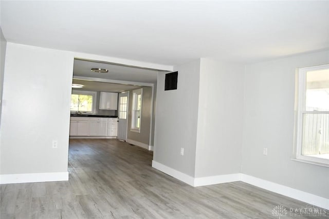 unfurnished room featuring light hardwood / wood-style floors and sink