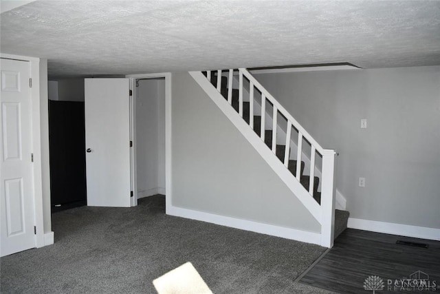 stairs with carpet and a textured ceiling