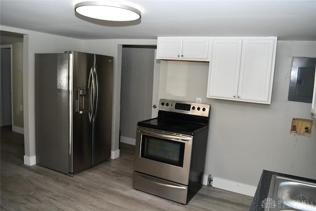 kitchen with electric panel, light hardwood / wood-style flooring, white cabinets, and appliances with stainless steel finishes