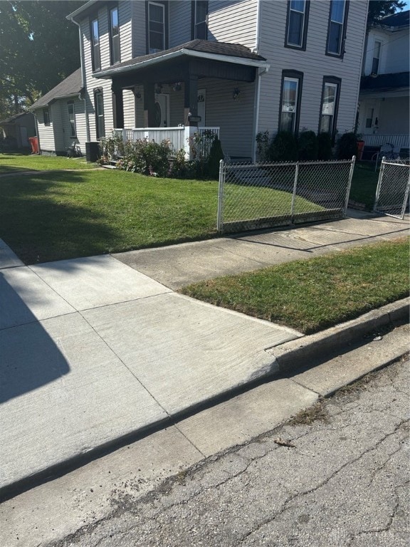 view of front of property with cooling unit, a front lawn, and a porch