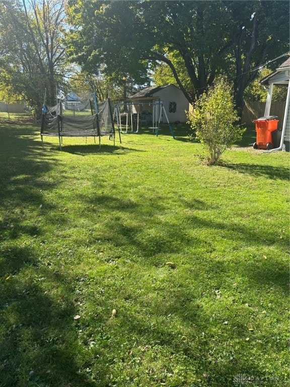 view of yard with a playground and a trampoline