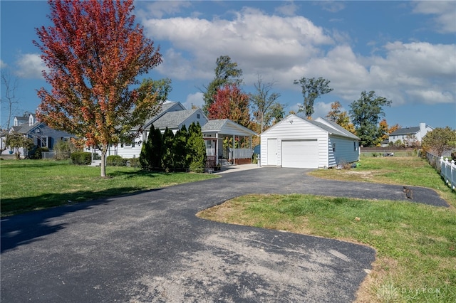 view of front of property featuring an outdoor structure, a garage, and a front lawn