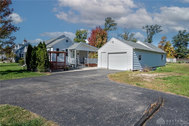 view of front of property featuring a front yard, covered porch, and an outbuilding