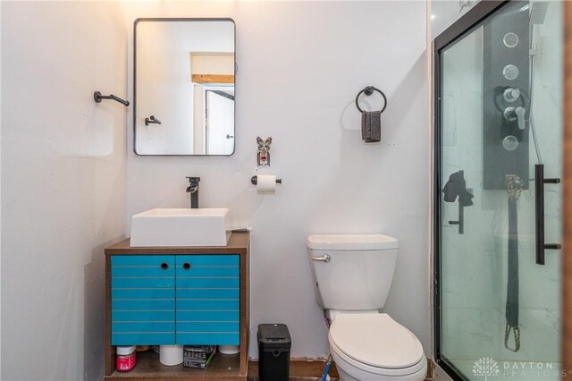 bathroom featuring vanity, toilet, and a shower with shower door