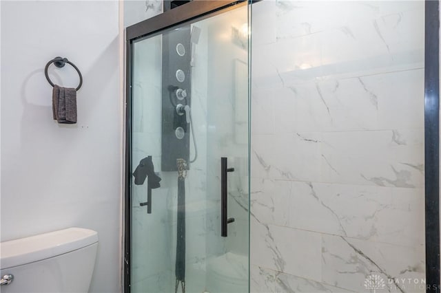 full bathroom with toilet and a marble finish shower