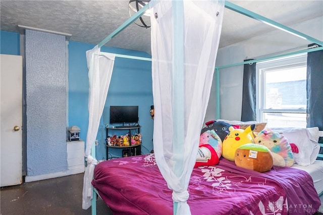 bedroom with a textured ceiling and concrete floors