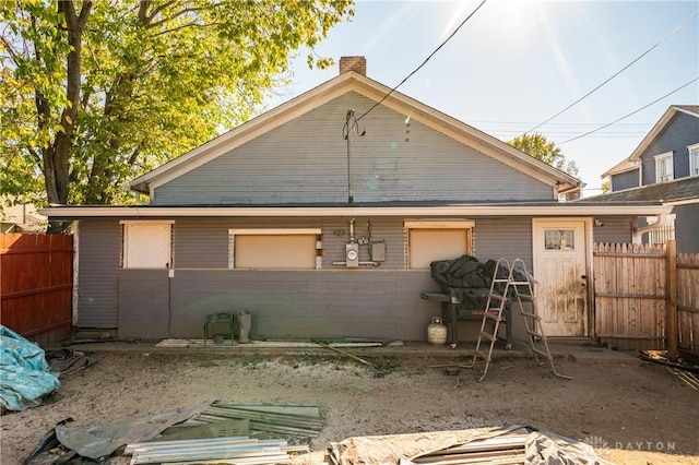 view of side of property with a chimney and fence