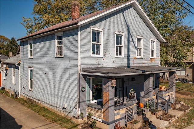 view of front of house featuring a porch and a chimney