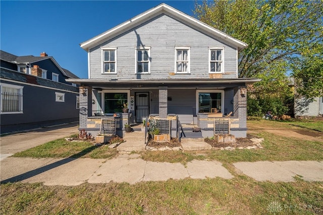 view of front facade featuring covered porch and brick siding