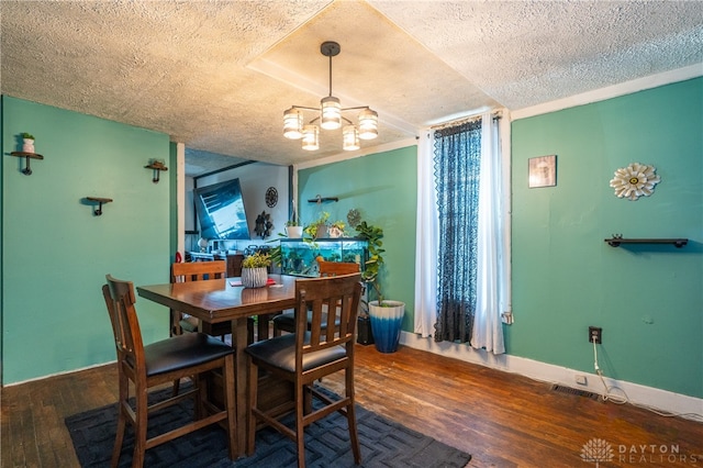 dining space featuring an inviting chandelier, a textured ceiling, and hardwood / wood-style flooring