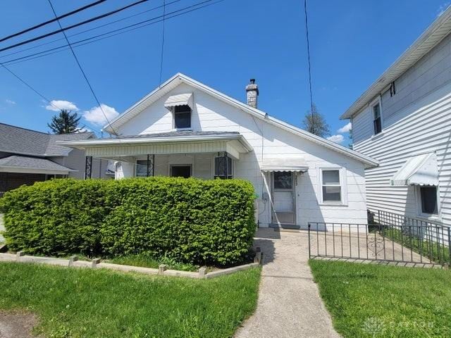 bungalow-style home with a front lawn