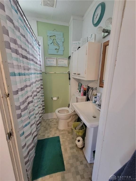 bathroom featuring sink, crown molding, and toilet