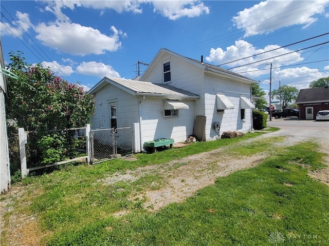 view of side of home with an AC wall unit and a yard