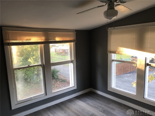 spare room with dark wood-type flooring, plenty of natural light, lofted ceiling, and ceiling fan