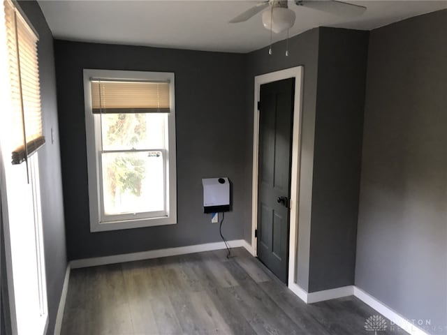 empty room with ceiling fan and dark hardwood / wood-style flooring