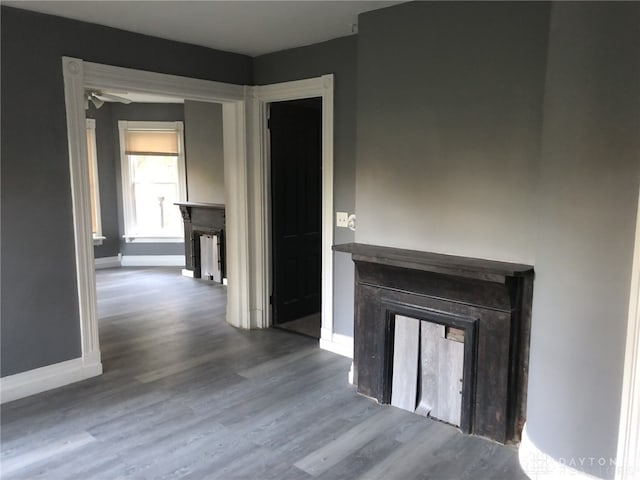 hallway featuring wood finished floors and baseboards